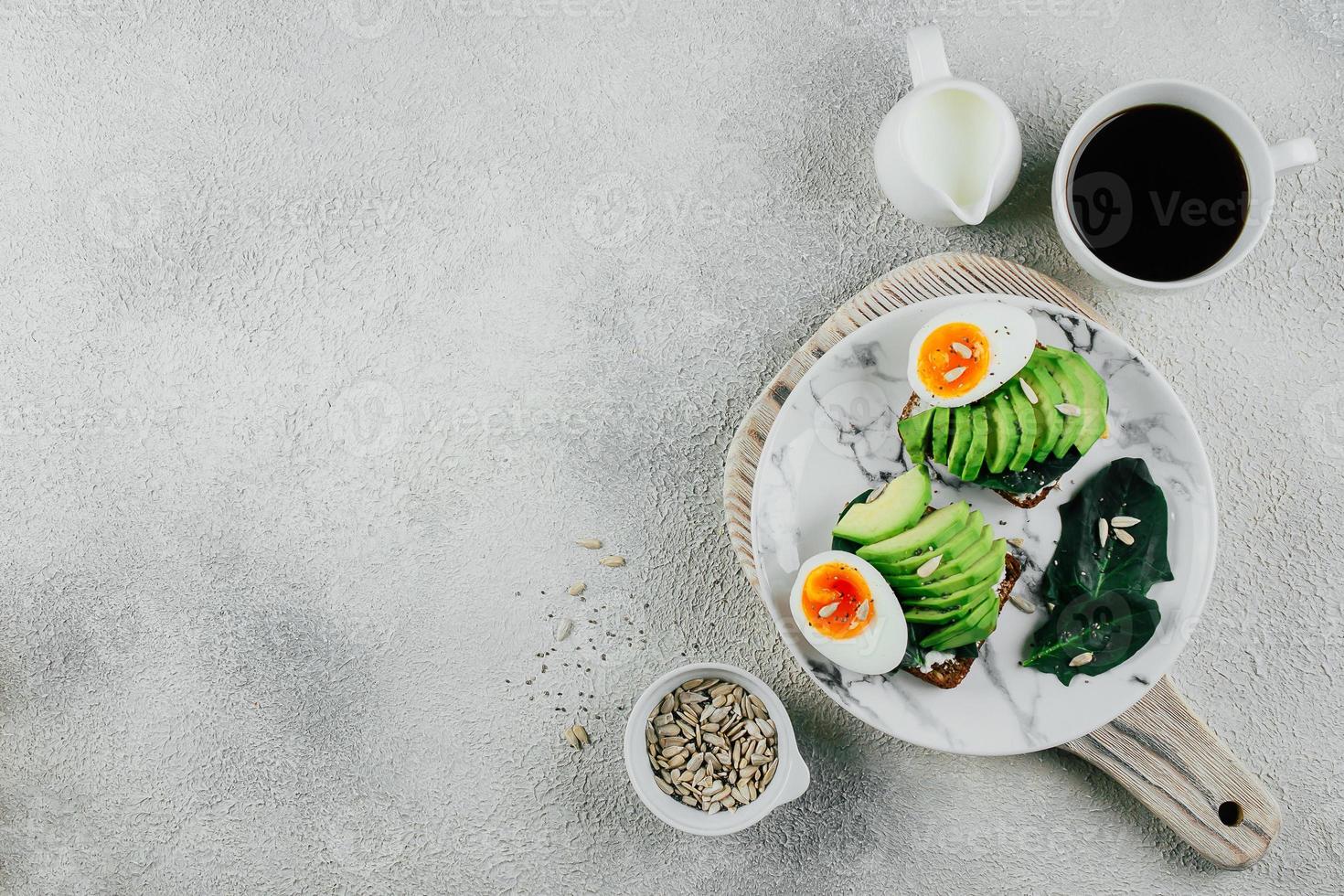 Essen Hintergrund mit Avocado Toast auf Roggen Korn Brot. Tasse von Kaffee. gesund Frühstück Konzept foto