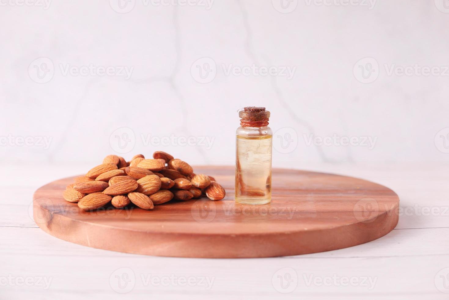 Mandelöl in der Flasche auf Schneidebrett auf dem Tisch foto