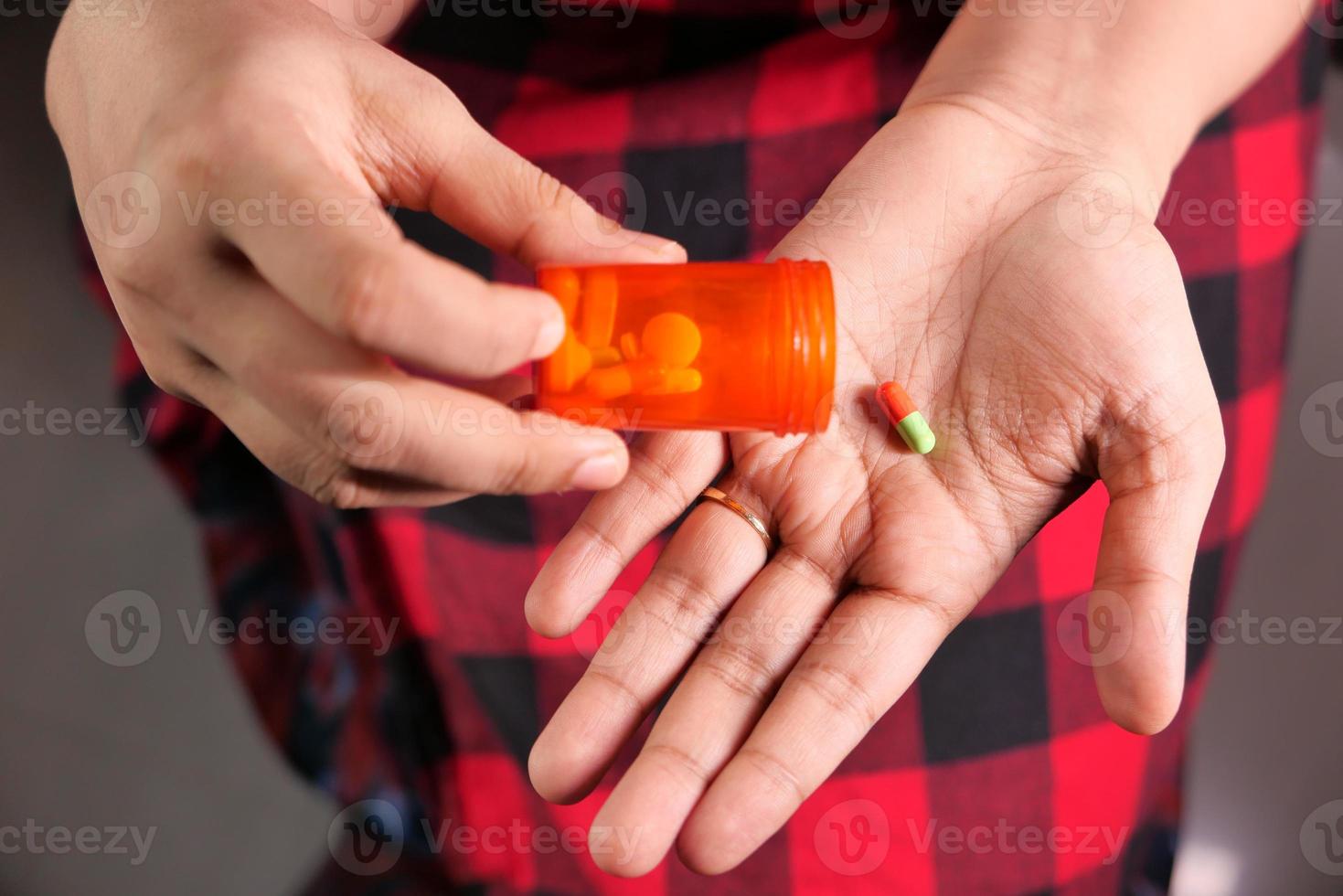 Draufsicht auf die Hände der Frau, die Pillen nehmen foto