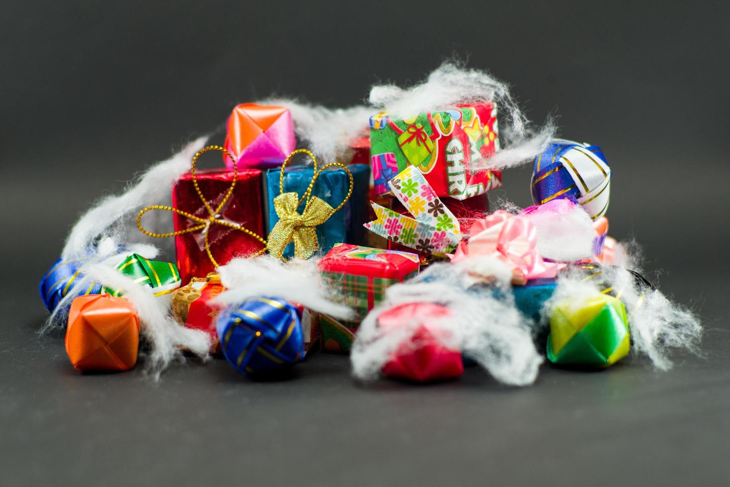 Nahaufnahmestapel der Geschenkboxen, die durch buntes Papier eingewickelt werden foto