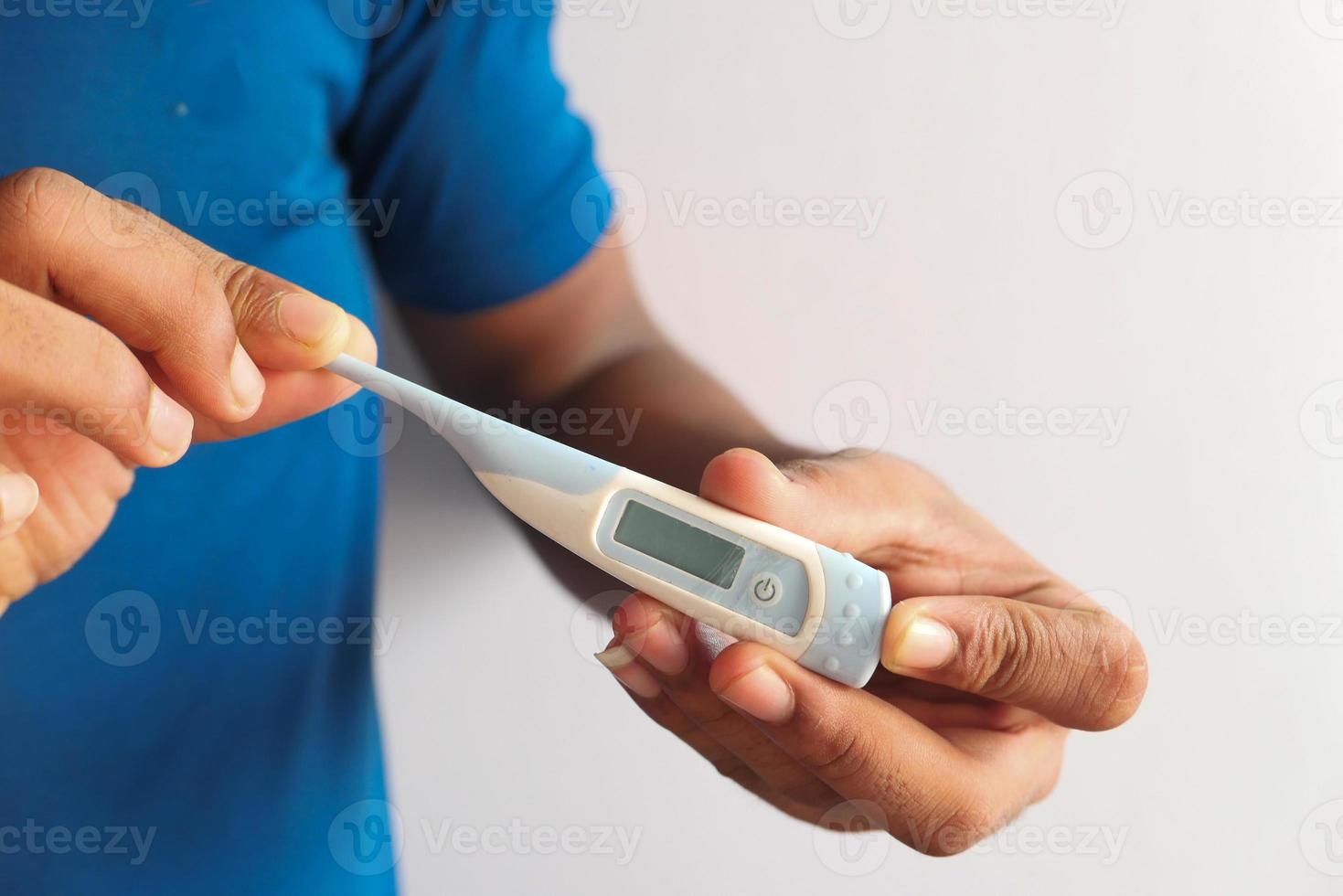 Nahaufnahme der Hand des Mannes, die digitales Thermometer hält foto