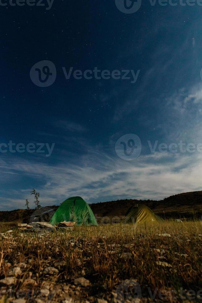 Zelt zum Camping auf das Strand auf das Hintergrund von das Seelandschaft im das Nacht foto