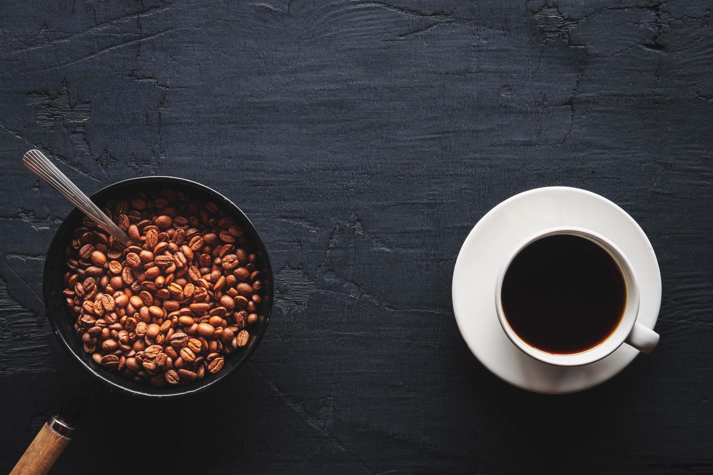 Draufsicht von Kaffee und Kaffeebohnen auf einem dunklen Hintergrund foto