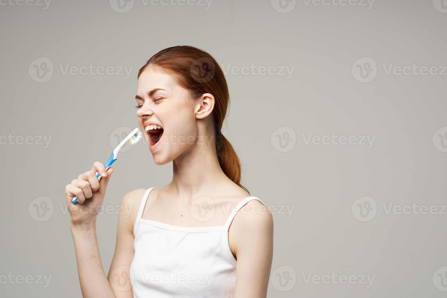 Frau im Weiß T-Shirt Dental Hygiene Gesundheit Pflege Licht Hintergrund foto