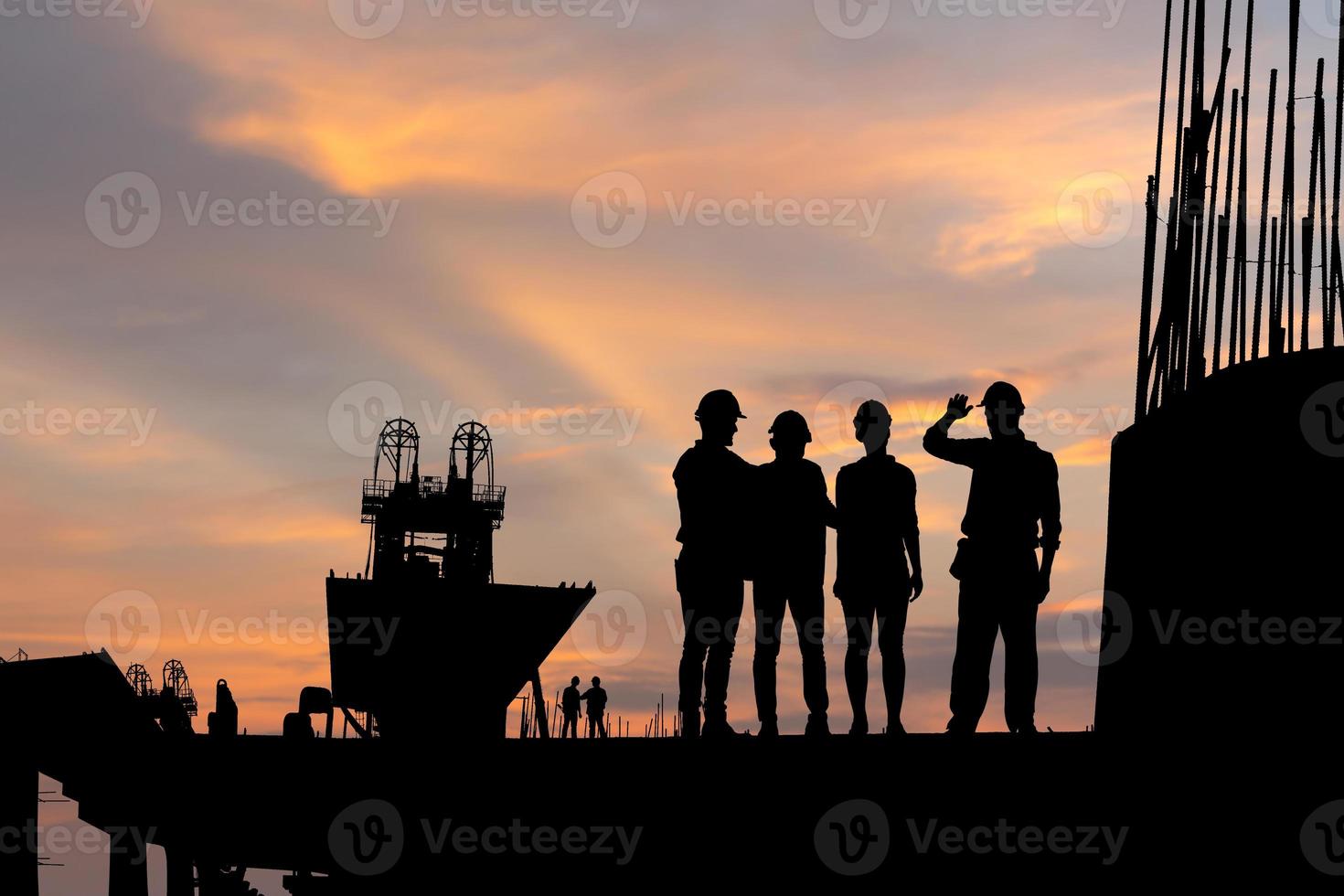 Silhouette von Ingenieur und Arbeiter Mannschaft Überprüfung Projekt beim Gebäude Seite? ˅ Hintergrund, Infrastruktur Konstruktion Seite? ˅ beim Sonnenuntergang im Abend Zeit foto