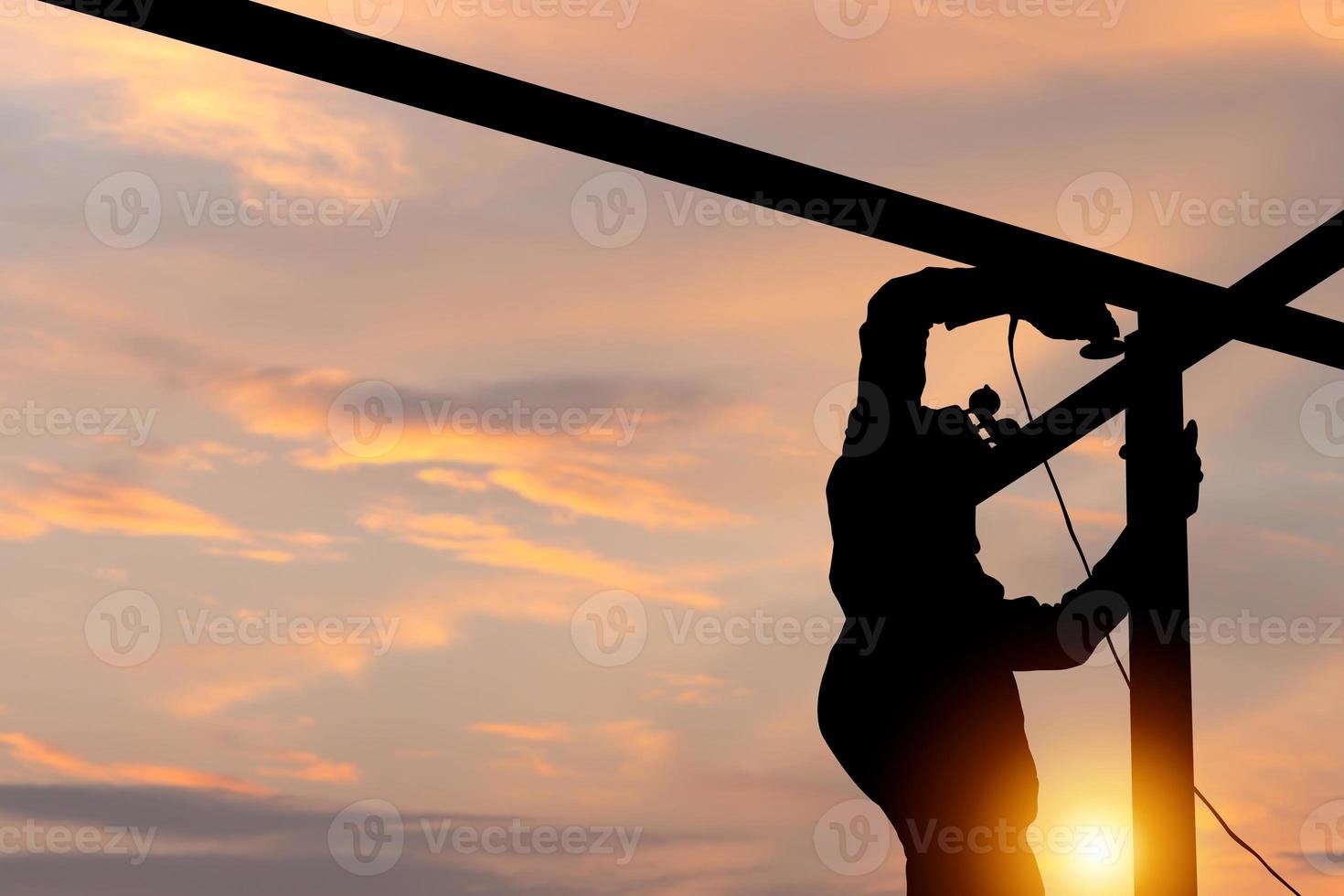 Silhouette von Schweißer Arbeiter auf Gebäude Grundstück, Mann Arbeiten im Konstruktion Seite? ˅ beim Sonnenuntergang im Abend Zeit foto