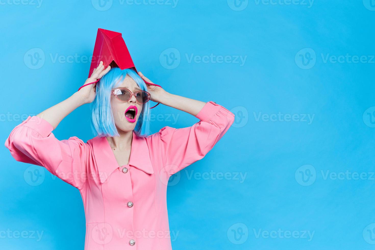 Frau im Rosa Kleid mit rot Paket auf ihr Kopf Studio foto