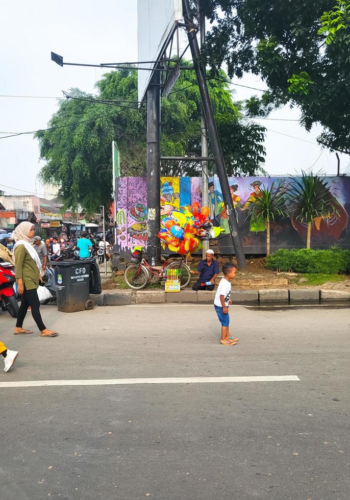 bekasi, Indonesien - - 12. März 2023 ein Mann ist Verkauf Luftballons und Seife Luftblasen beim das bekasi Auto kostenlos Tag Veranstaltung foto