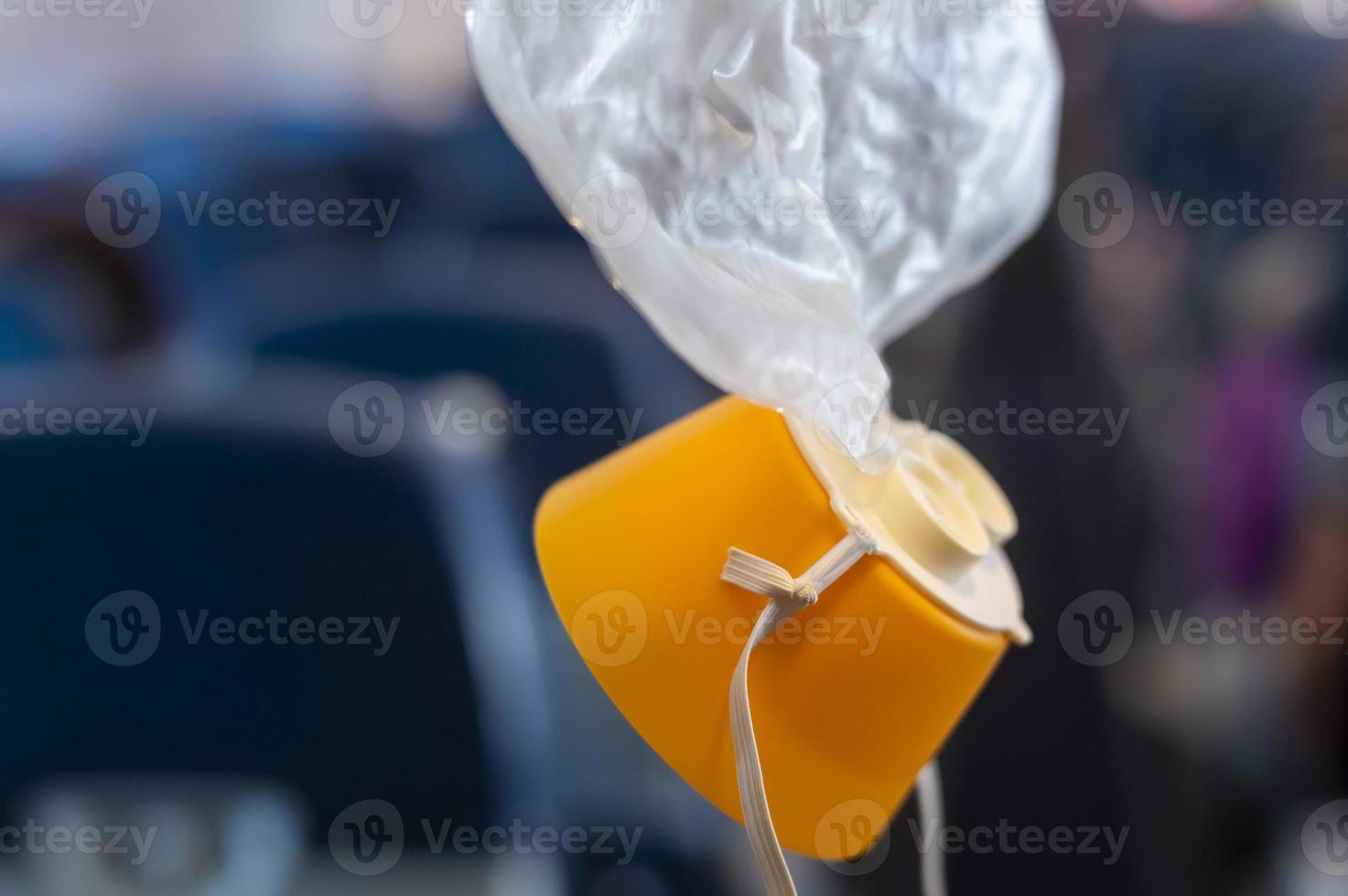 Tropfen der Sauerstoffmaske aus dem Deckenfach im Flugzeug foto