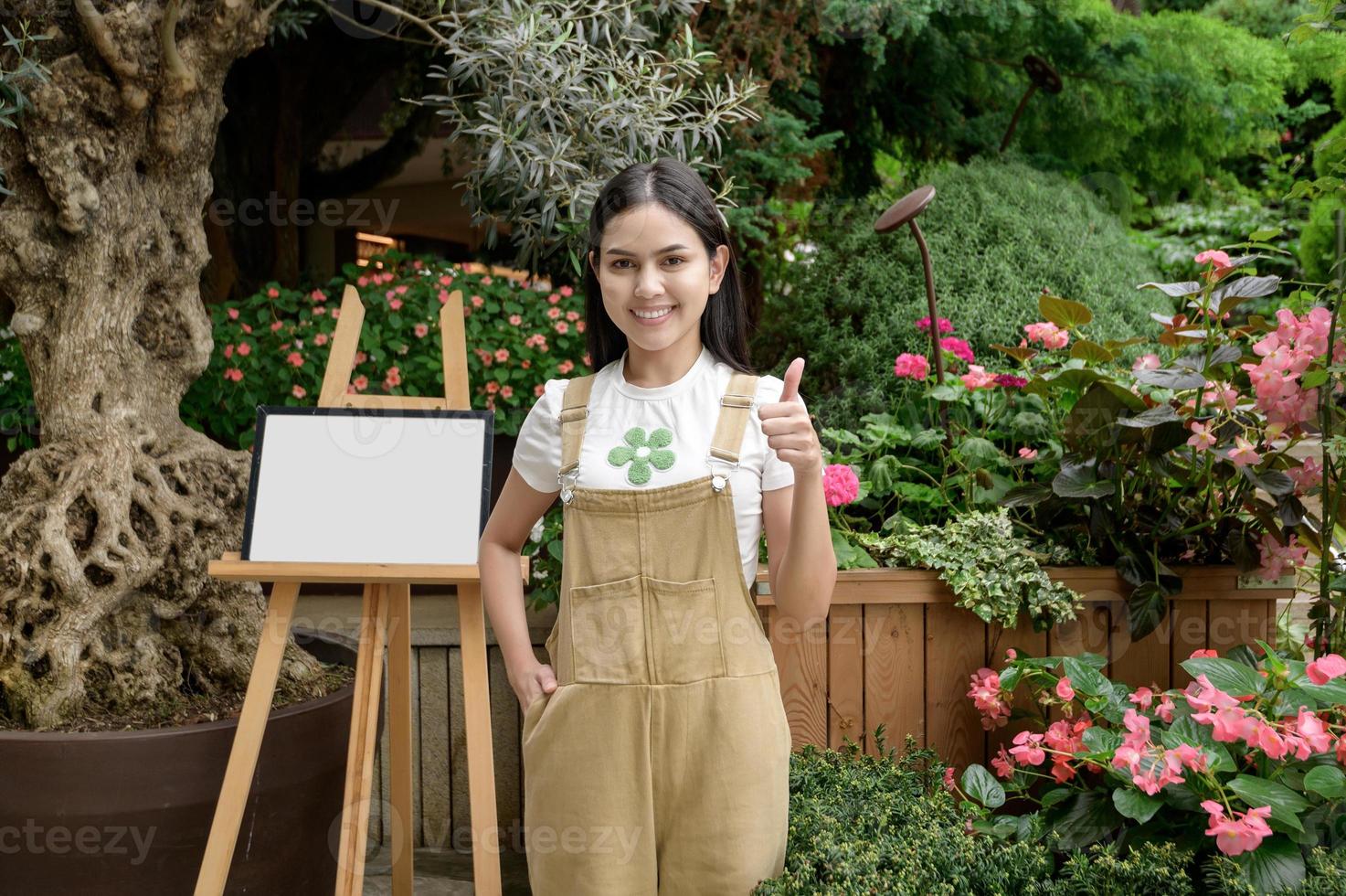 ein jung Frau ist lächelnd im ihr Blume Geschäft , klein Geschäft Konzept. foto