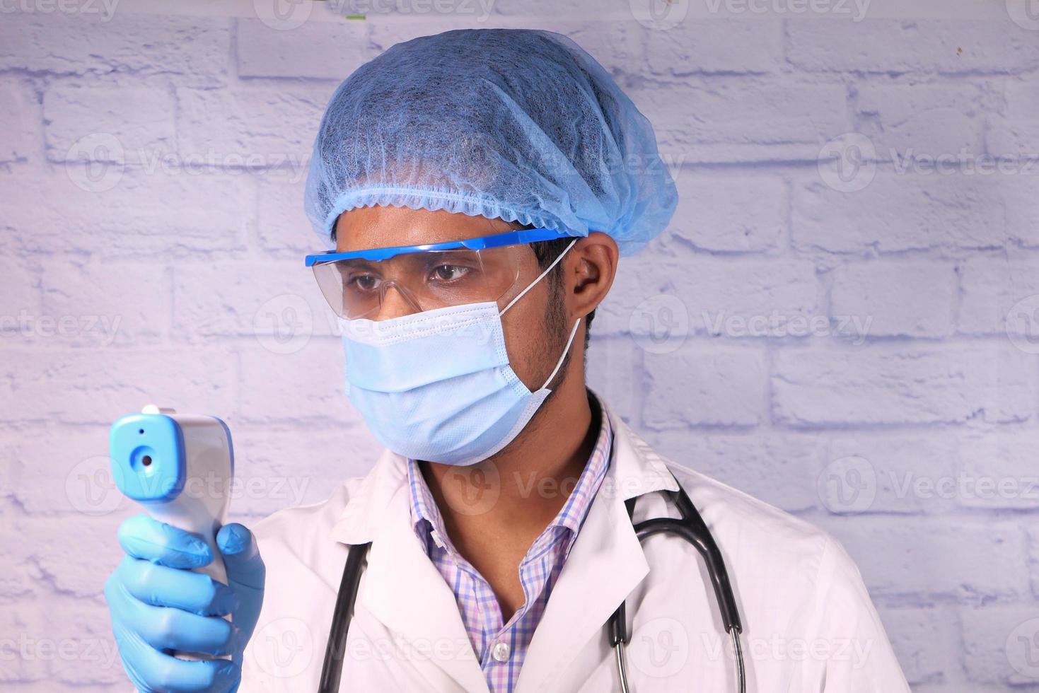 Arzt hält ein Infrarot-Thermometer foto