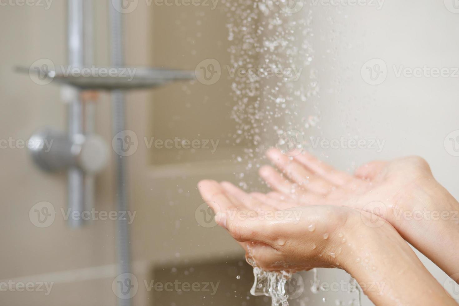 ein Frau Verwendet Hand zu messen das Wasser Temperatur von ein Wasser Heizung Vor nehmen ein Dusche foto