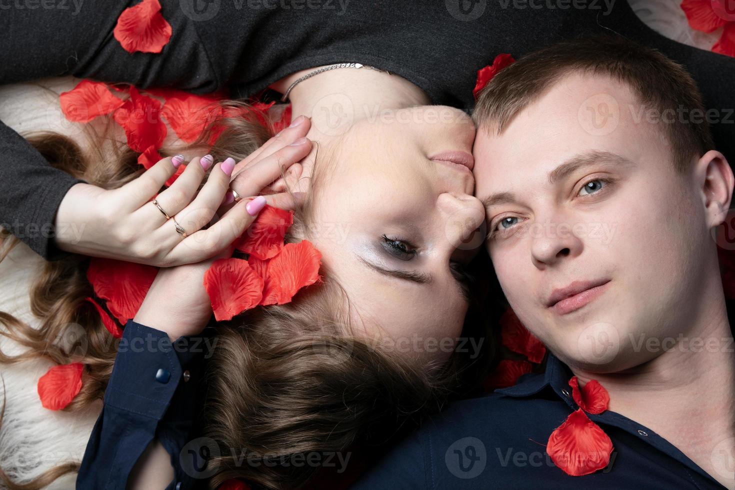 liebend Paar. Mann und Frau im Rose Blütenblätter. schön jung Mann und Gattin. foto