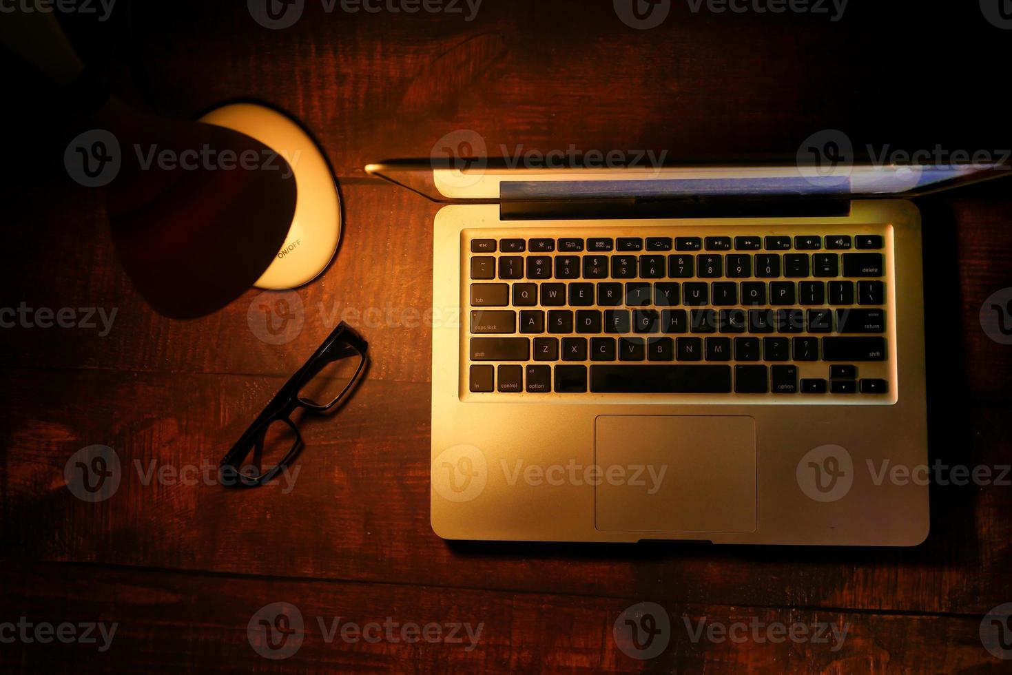 Laptop mit Tischlampe auf dem Schreibtisch foto