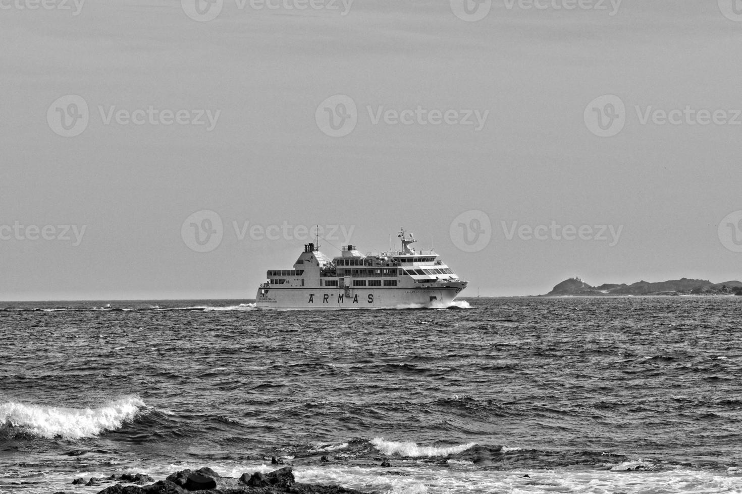 Meer Landschaft mit das Ozean und ein Aussicht von das Spanisch Insel von de Lobos mit ein Schiff im das Hintergrund foto