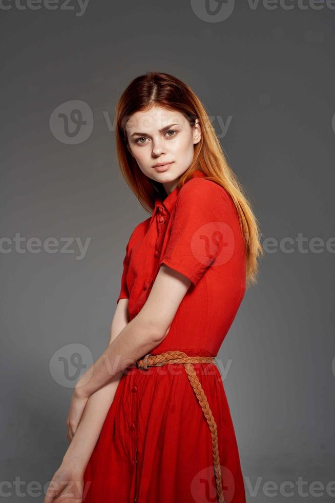 rothaarig Frau im rot Kleid posieren attraktiv aussehen isoliert Hintergrund foto