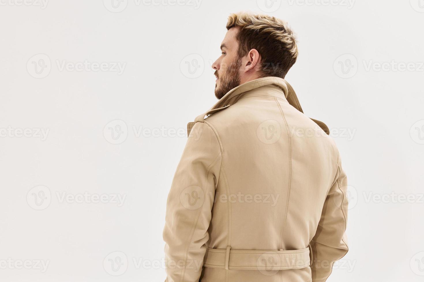 Mann im Beige Mantel modisch Frisur zurück Aussicht isoliert Hintergrund foto