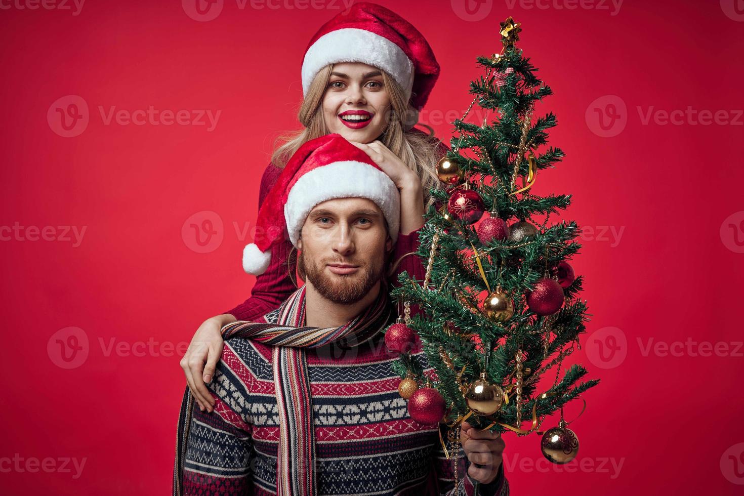 Mann und Frau Weihnachten Baum Dekoration Spaß Urlaub rot Hintergrund foto