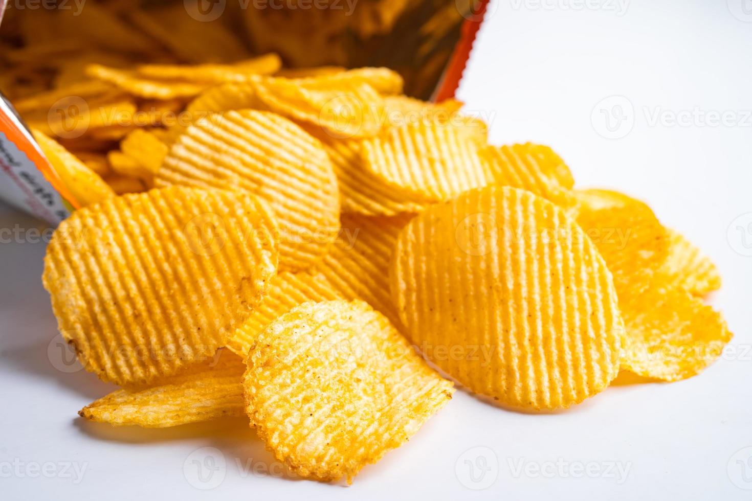 Kartoffelchips, leckeres Grillgewürz würzig für Crips, dünne Scheiben frittierter Snack Fast Food im offenen Beutel. foto