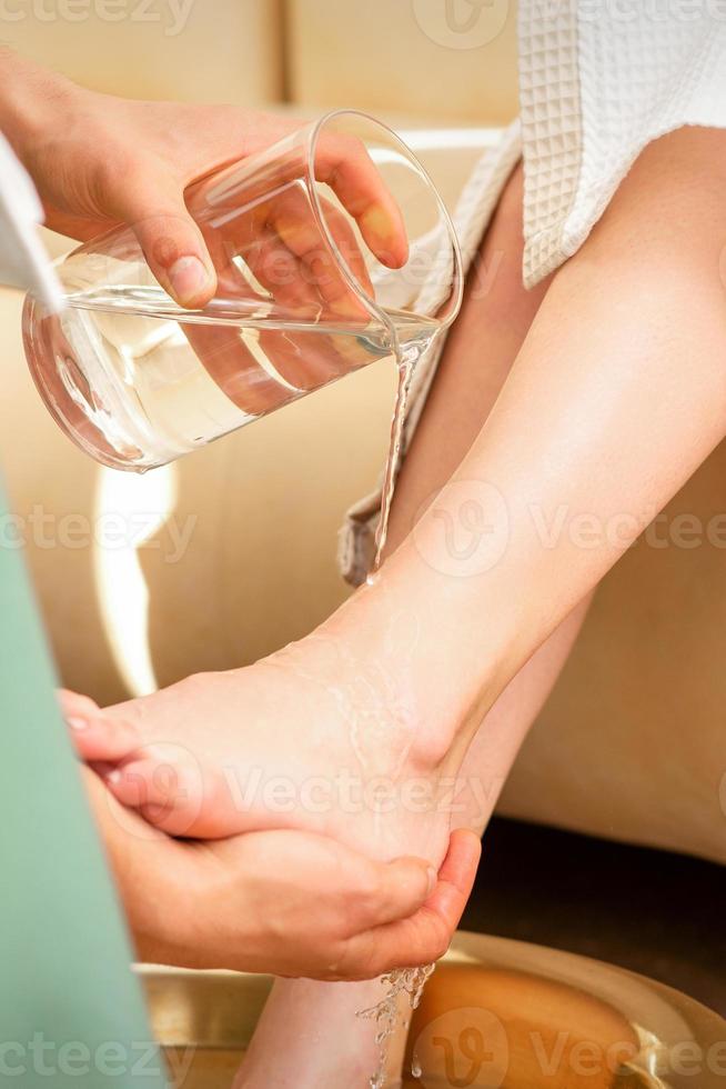 Hände von Therapeut Waschen Beine foto