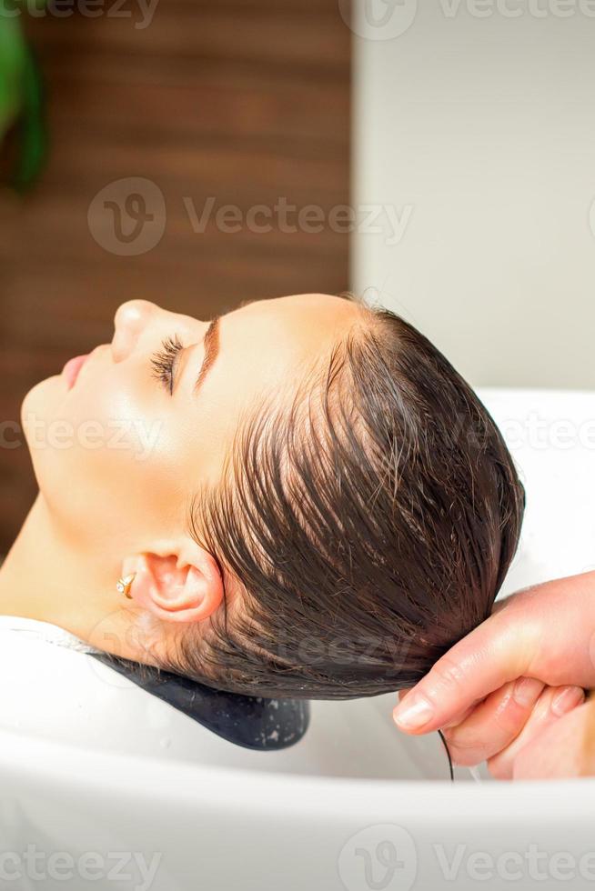 Friseur Waschen Haar von Klient foto