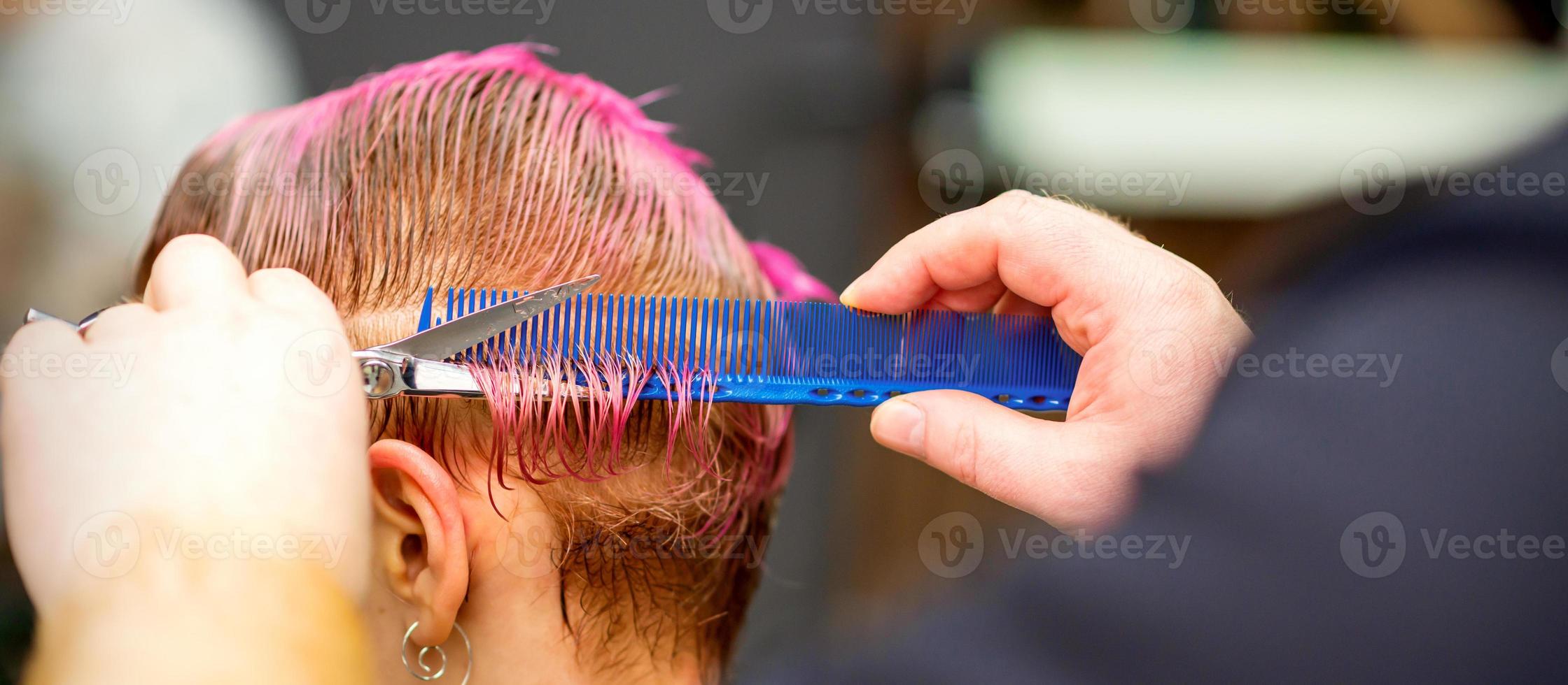 Frau mit Rosa Haar bekommen kurz Haarschnitt foto