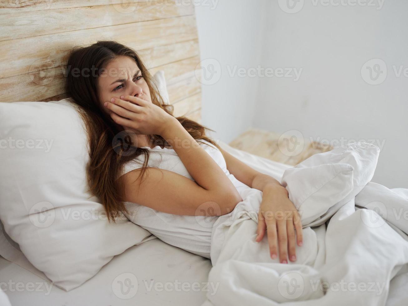 Frau Lügen im Bett bedeckt mit ein Decke Krankheit hoch Fieber foto