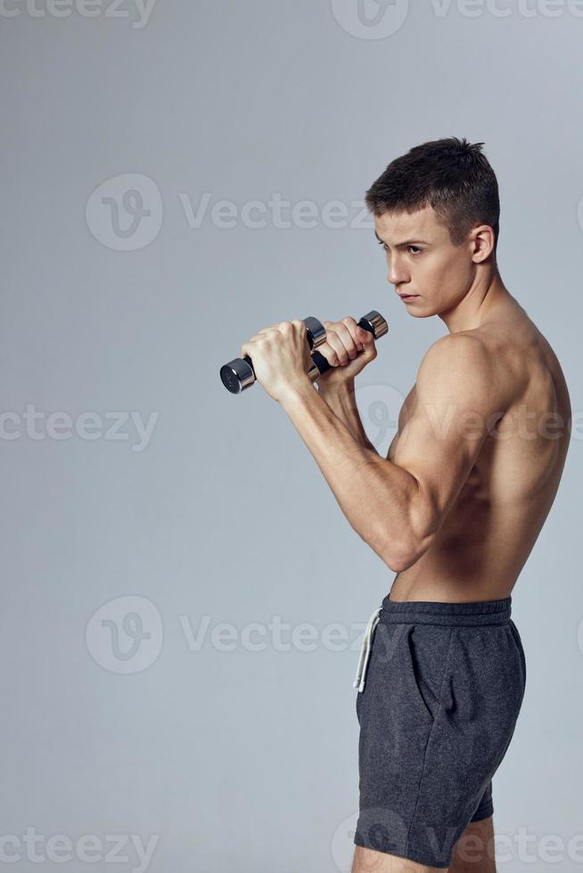 Kerl mit aufgeblasen Körper Hanteln im Hände trainieren Übungen isoliert Hintergrund foto