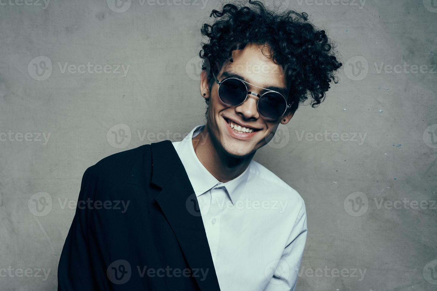 glücklich Mann blendend Lächeln lockig Haar Brille Modell- Hemd Jacke foto