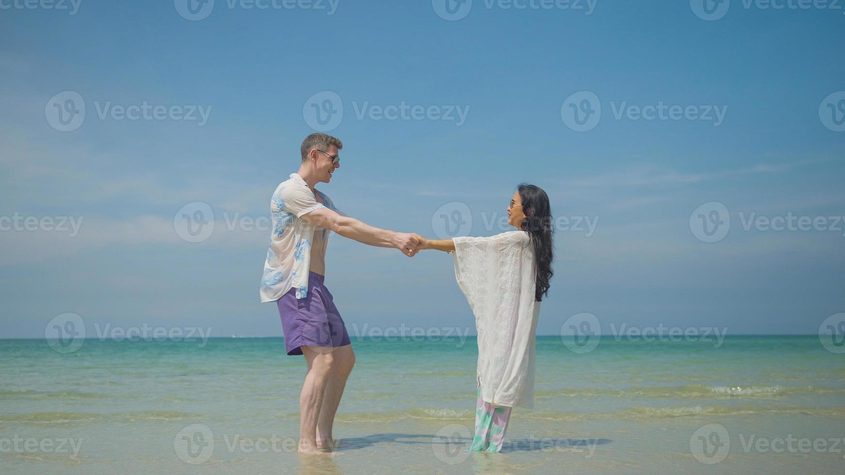 Paare halt Hände und gehen entlang das Strand auf ihr Sommer- Ferien und Sie Lächeln und haben Spaß auf Urlaub. foto