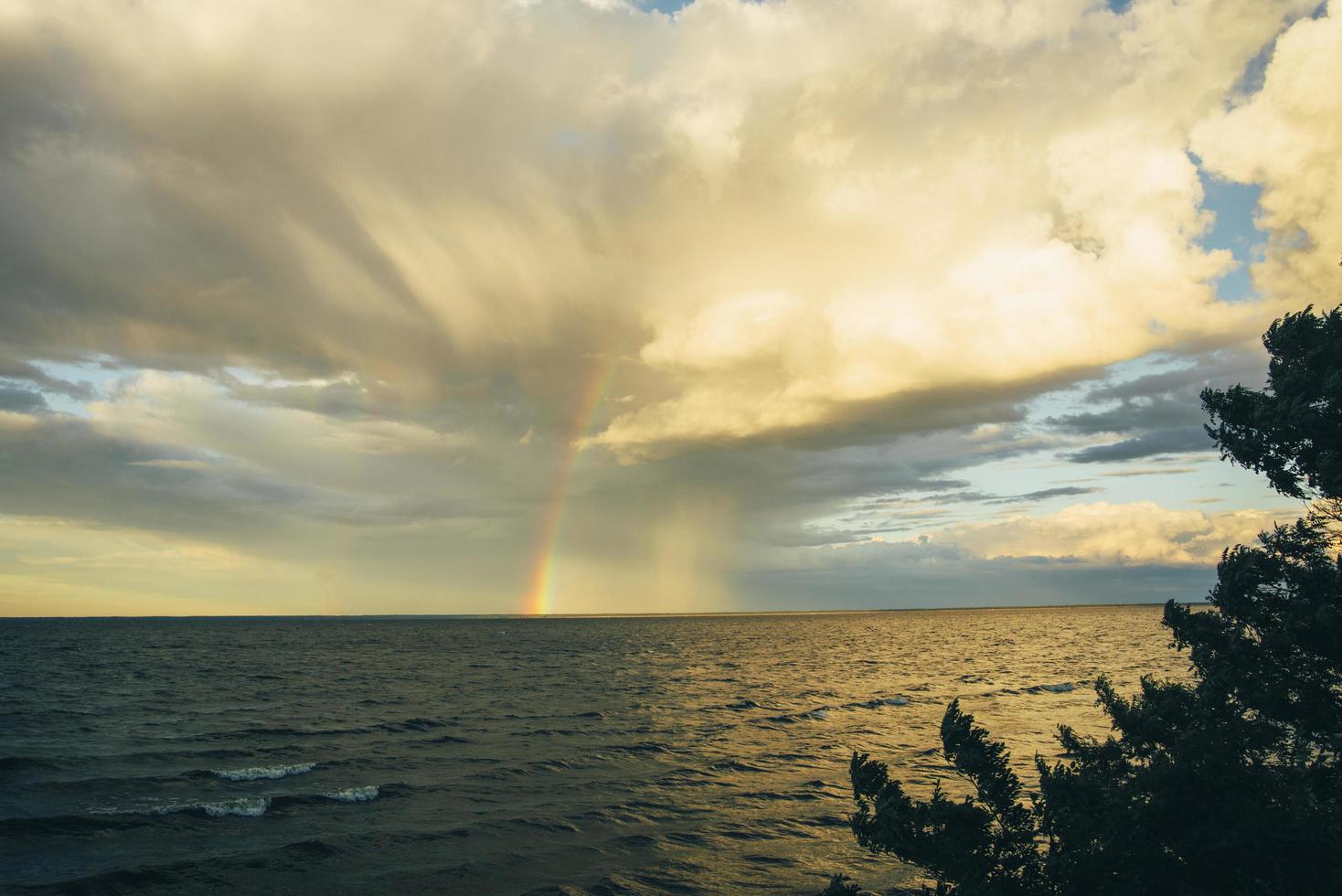 Regenbogen auf dem Meer durch Wolken foto