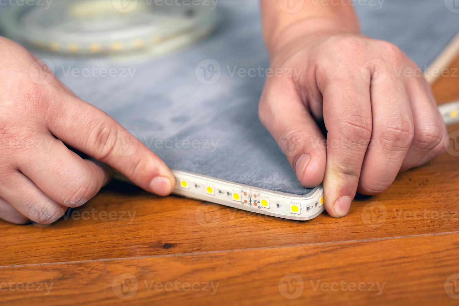 Arbeiter installiert Streifen LED-Beleuchtung foto