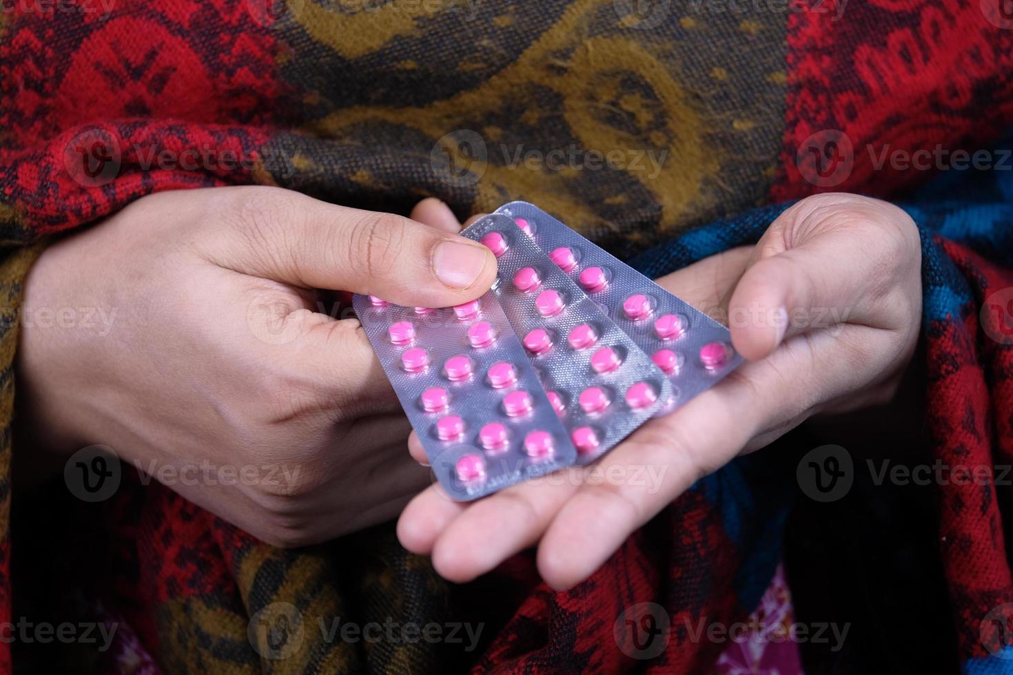 Frauenhand, die rosa Pillen hält foto