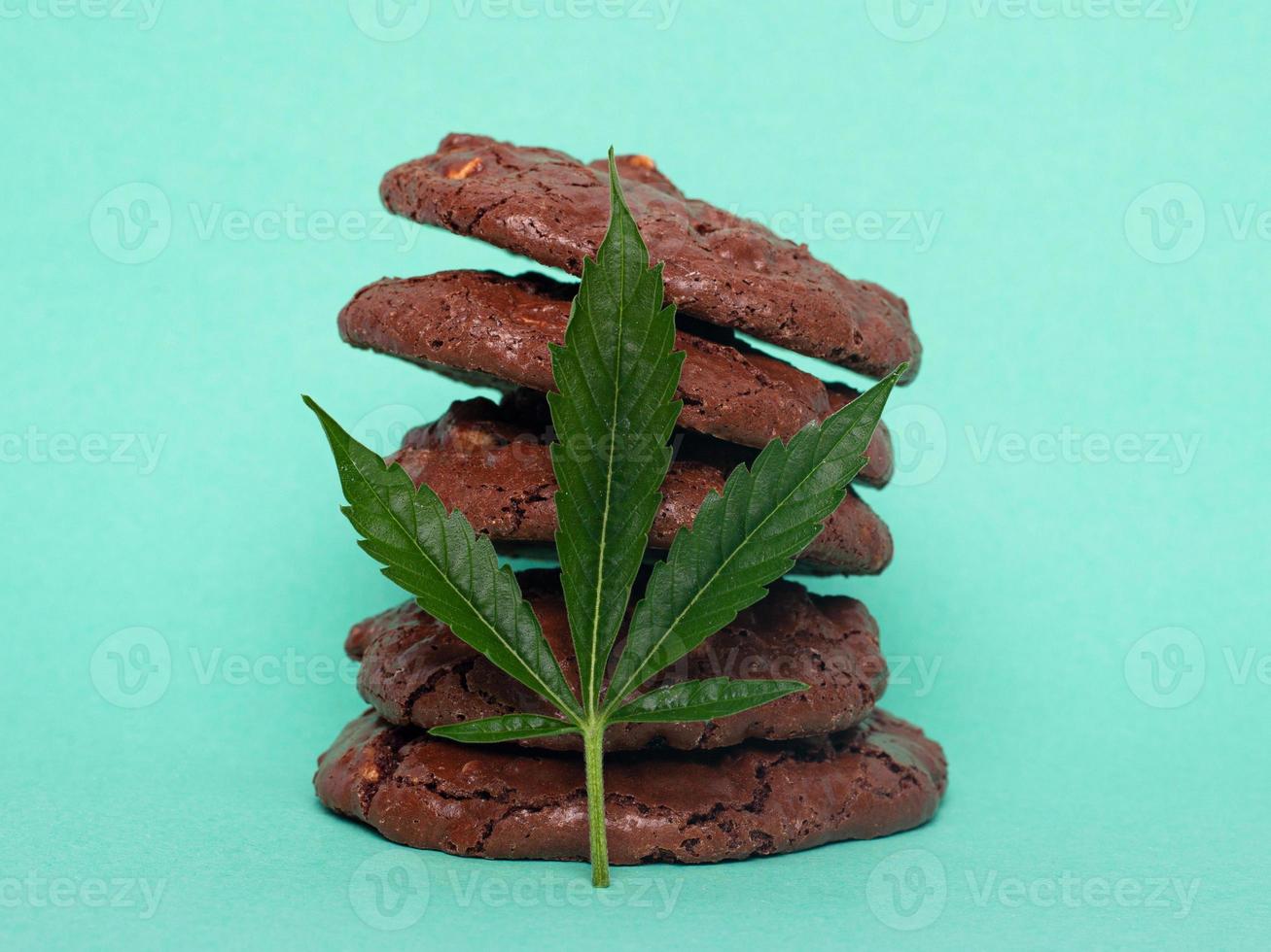Haferkekse und grünes Cannabisblatt auf einem blauen Hintergrund foto