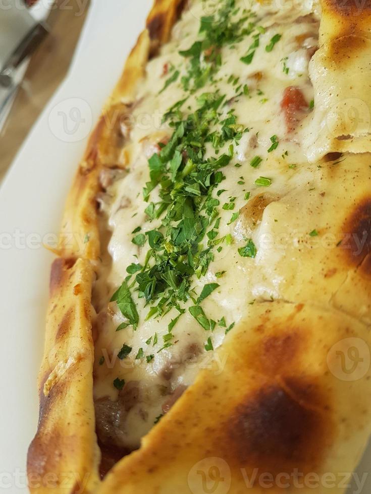 traditionell Türkisch Küche Kasarli pide bootförmig Fladenbrot mit Käse, Gewürze und Kräuter foto