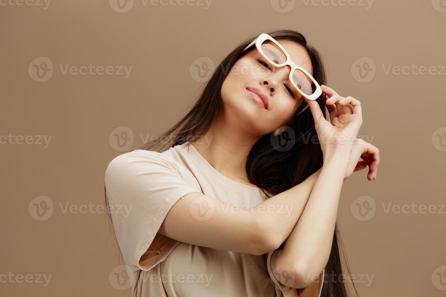 jung Frau im ein Beige T-Shirt mit Brille posieren Kleidung Mode isoliert Hintergrund foto