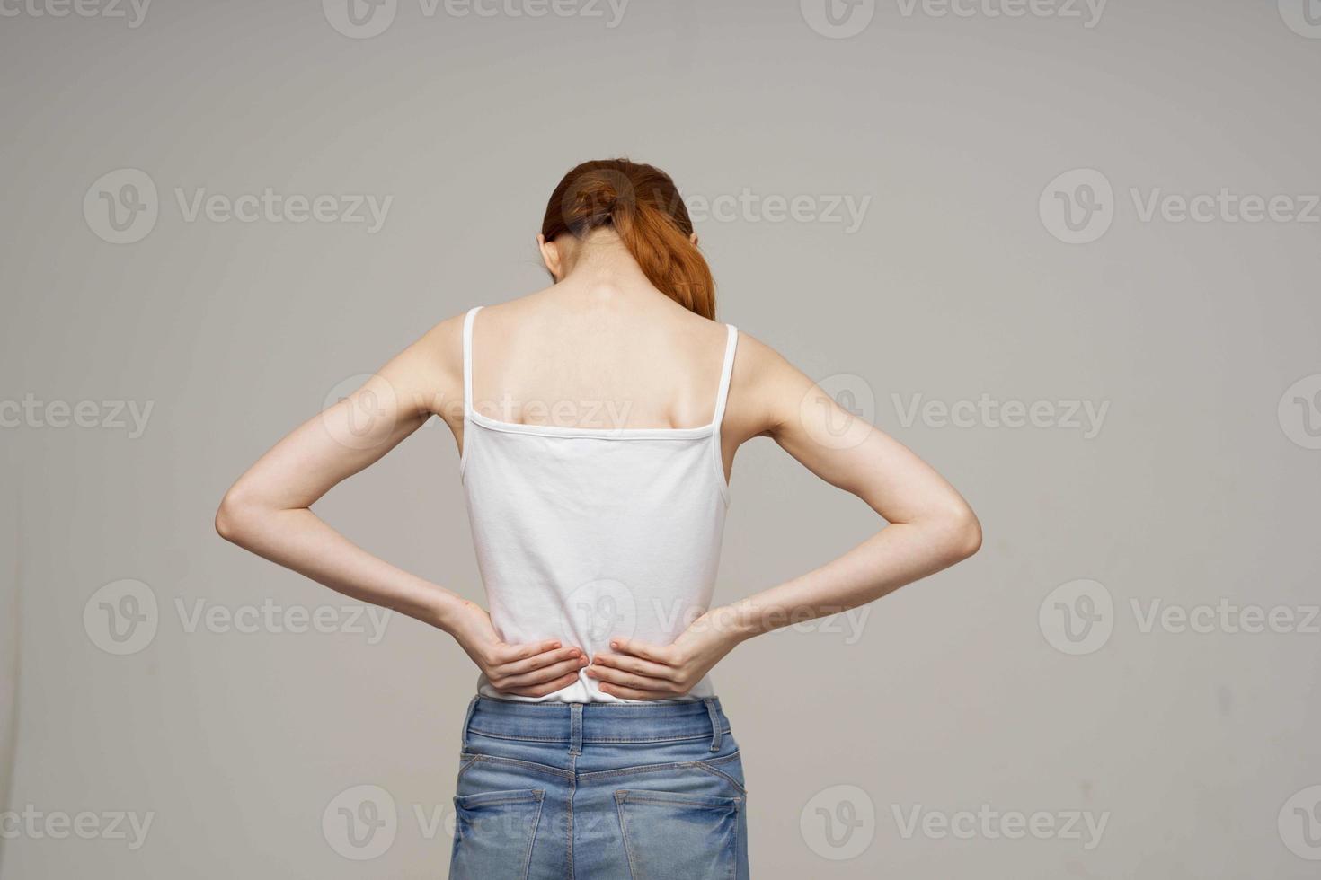 Frau im Weiß T-Shirt zurück Schmerzen Gesundheit Probleme Osteoporose Studio Behandlung foto