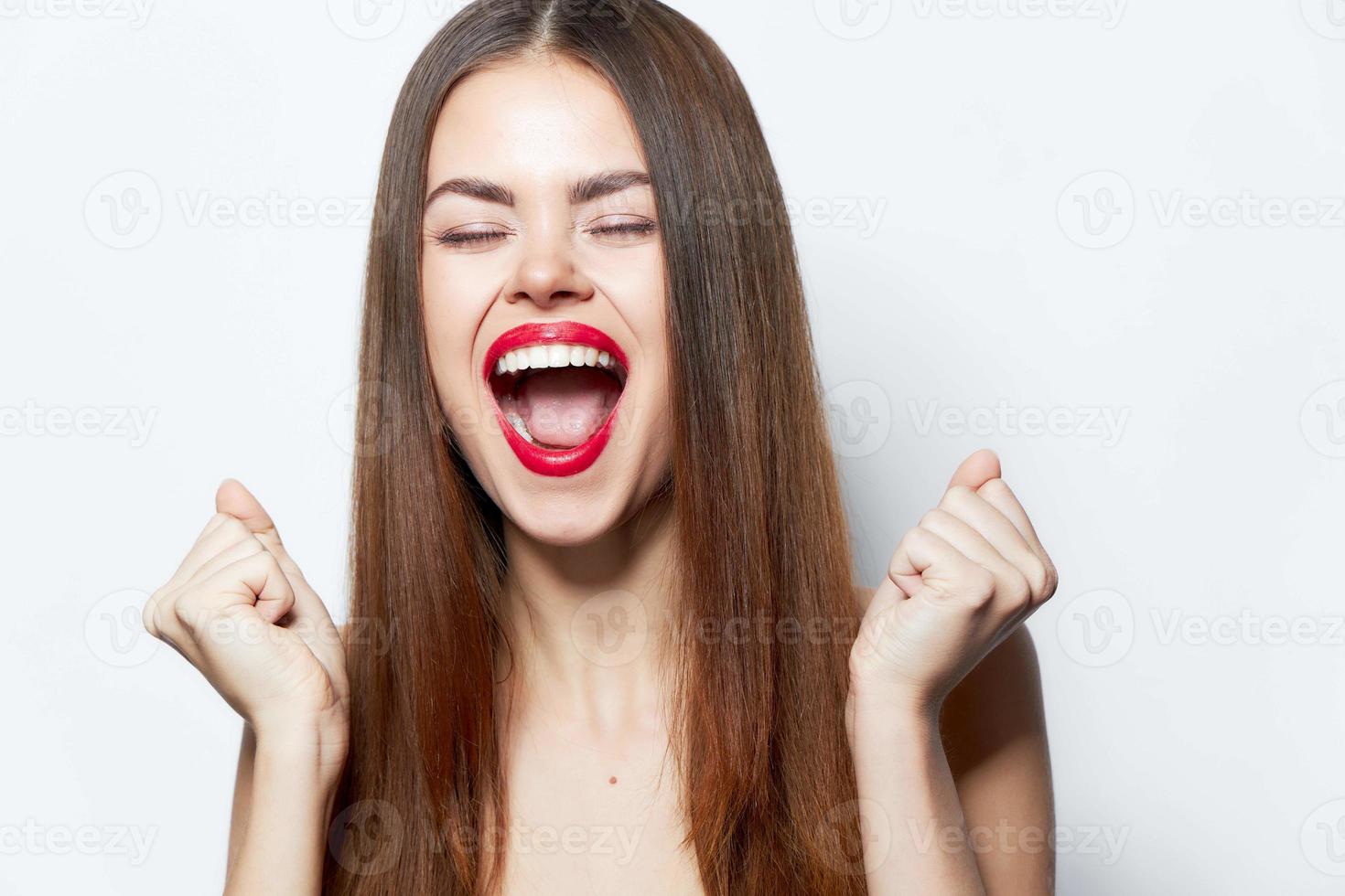 attraktiv Frau geöffnet ihr Mund breit und lacht, Zusammenpressen ihr Hände in ein Faust klar foto