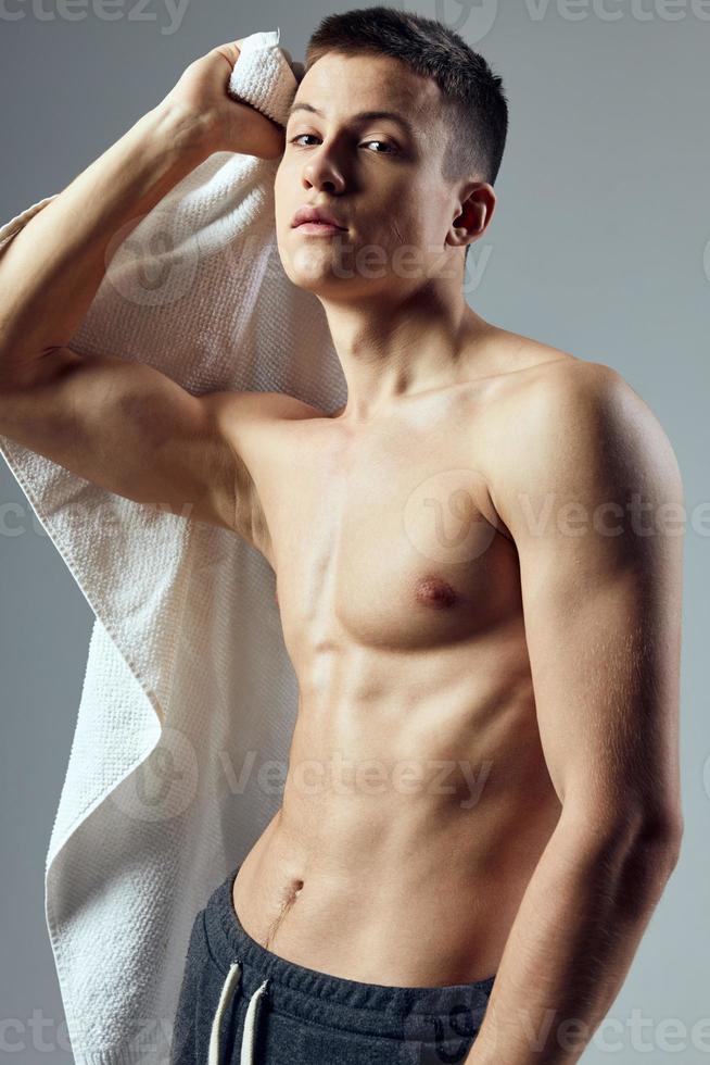 sportlich Mann mit ein gepumpt oben Torso Weiß Handtuch Fitness Lebensstil foto