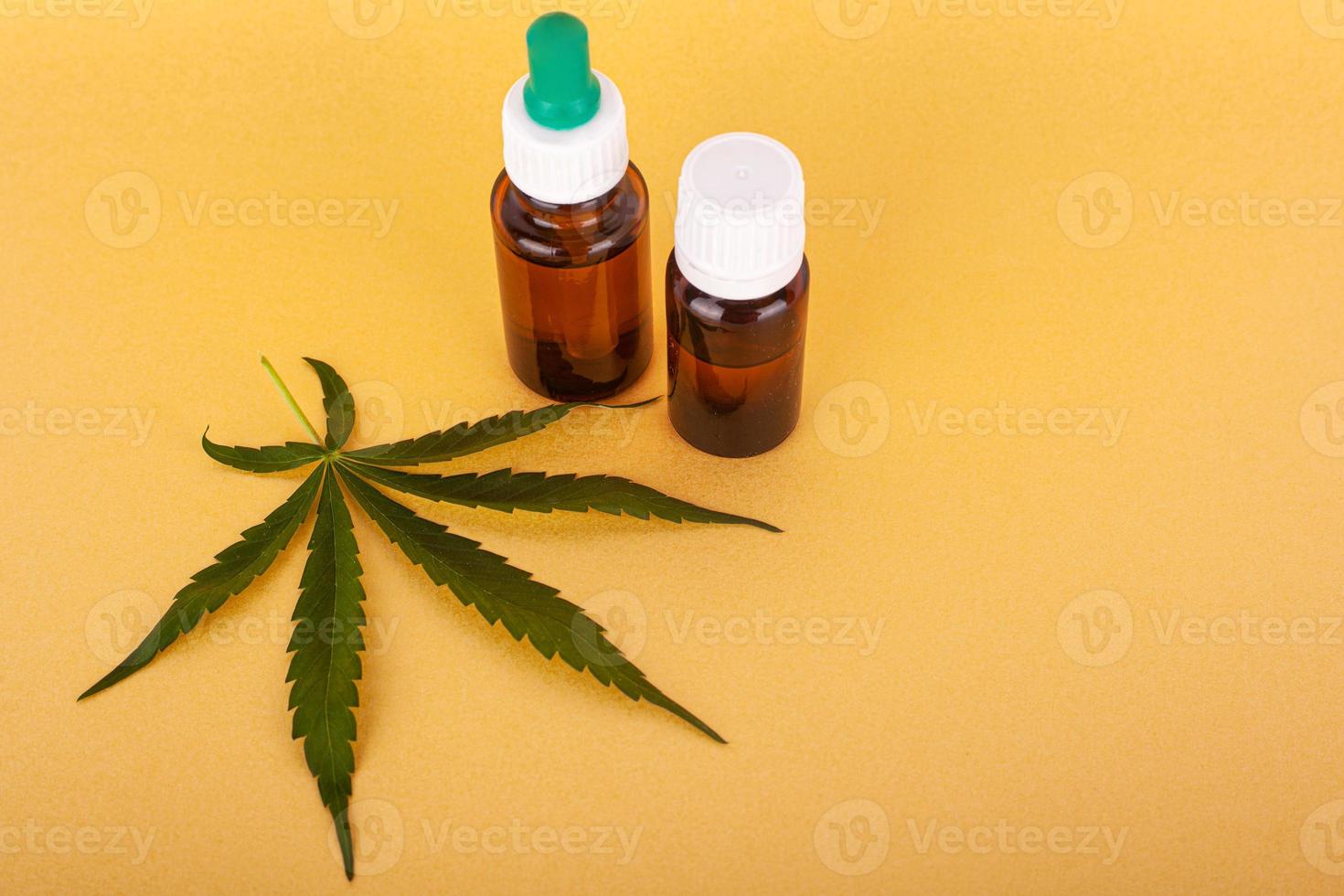 medizinischer Cannabisextrakt, der thc und cbd auf gelbem Hintergrund enthält foto