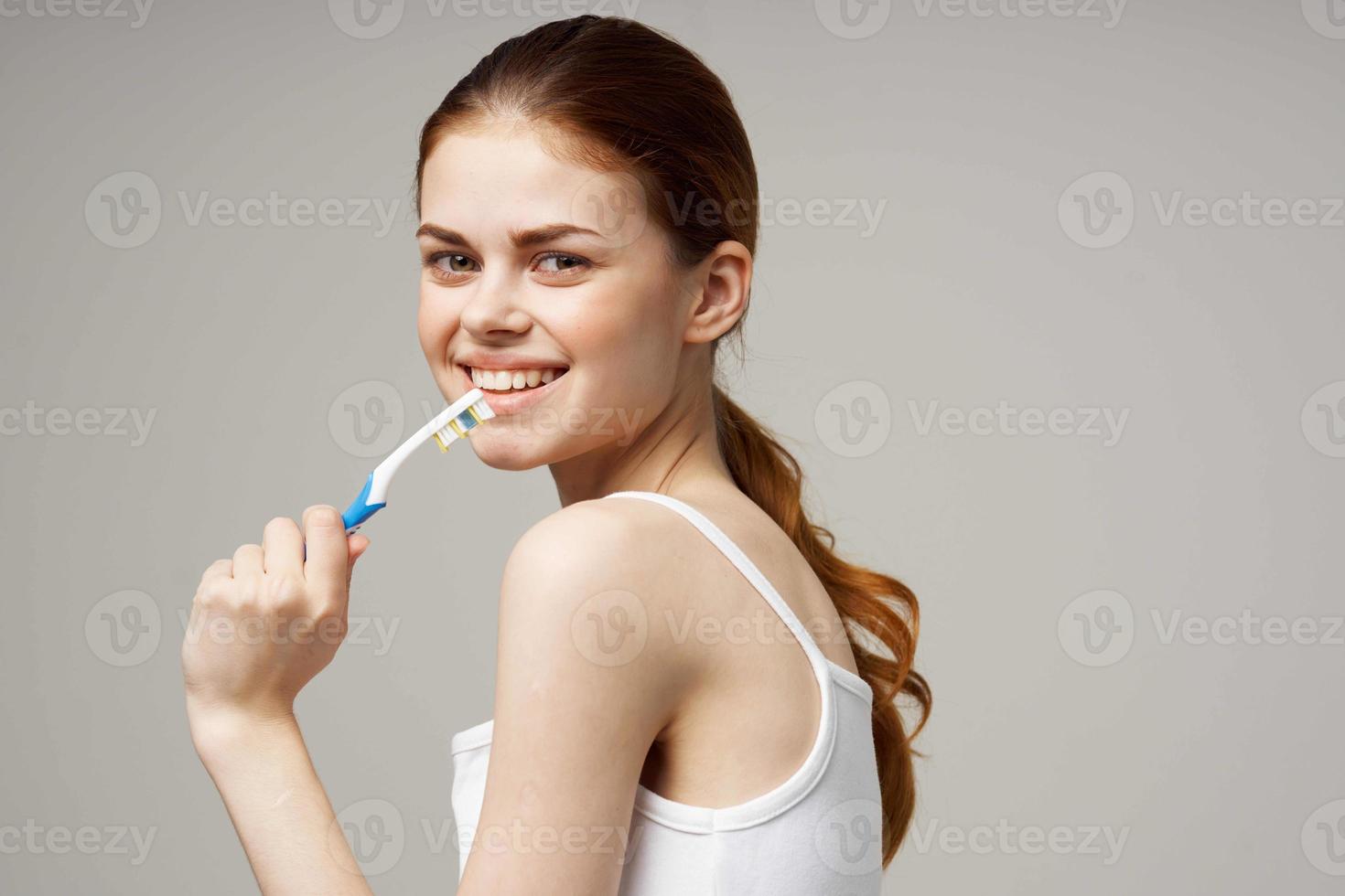 ziemlich Frau im Weiß T-Shirt Dental Hygiene Gesundheit Pflege Licht Hintergrund foto