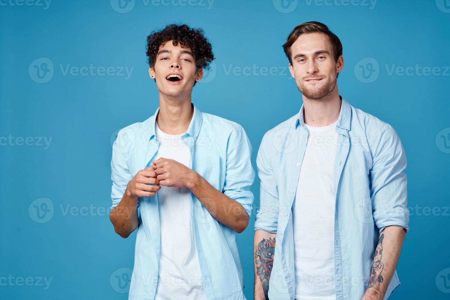 Männer im identisch Hemden und Weiß T-Shirts auf ein Blau Hintergrund chatten freunde abgeschnitten Aussicht foto