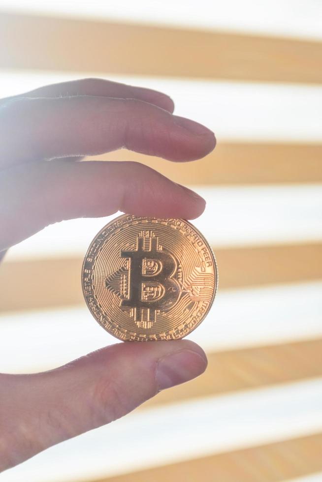 Mann hält Bitcoin in der Hand foto