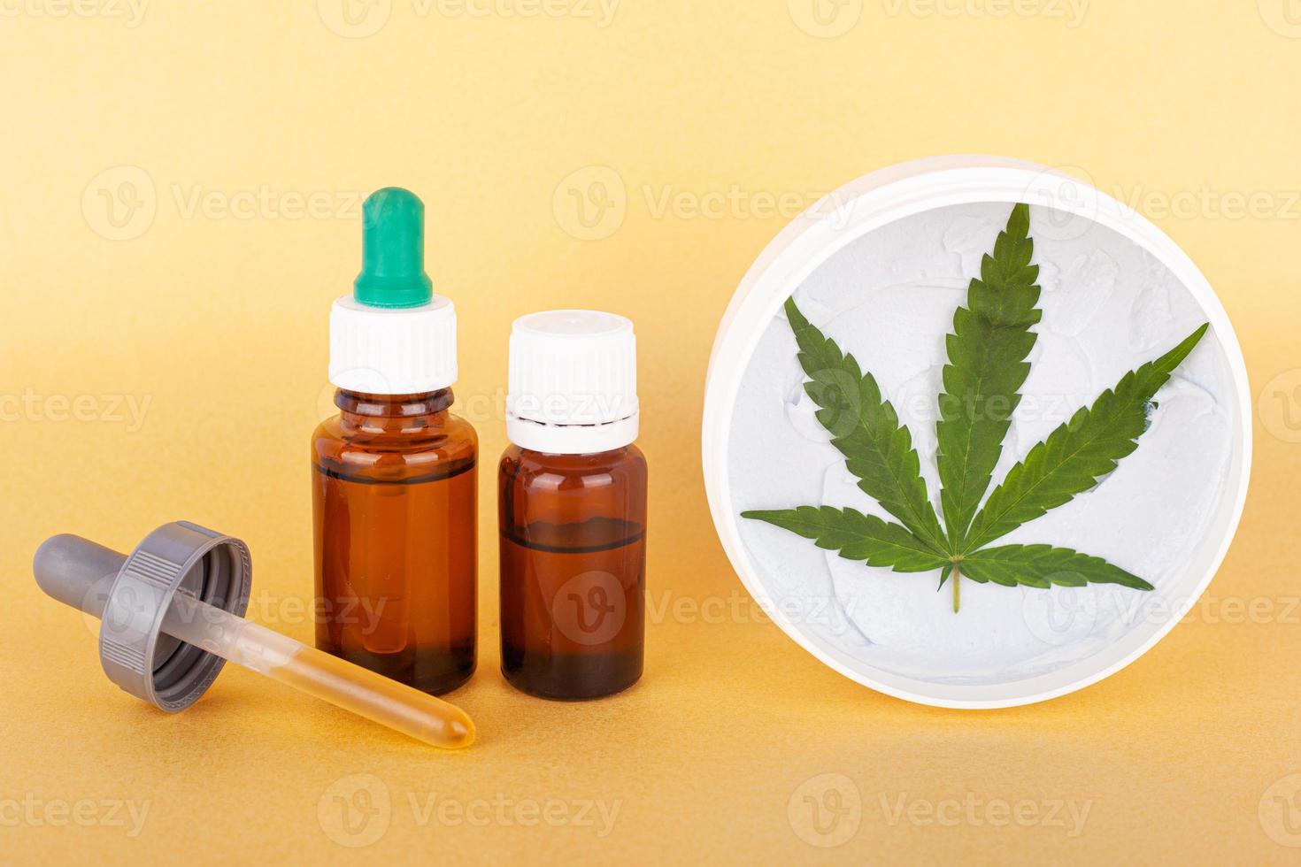 medizinische Cannabiscreme und Extrakt, die thc und cbd auf gelbem Hintergrund enthalten foto