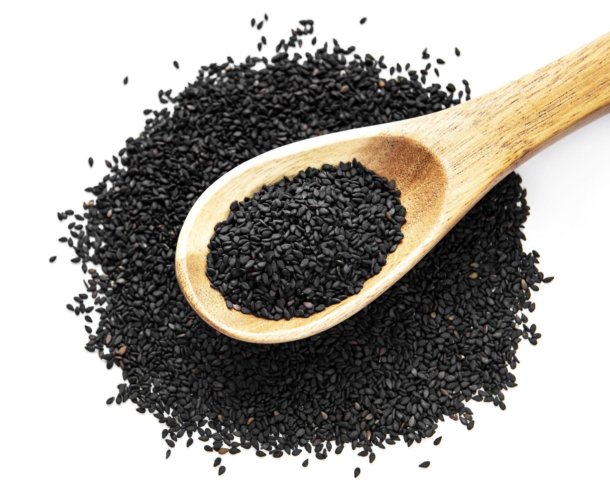 schwarzer Sesam in einem Löffel auf einem weißen Hintergrund foto