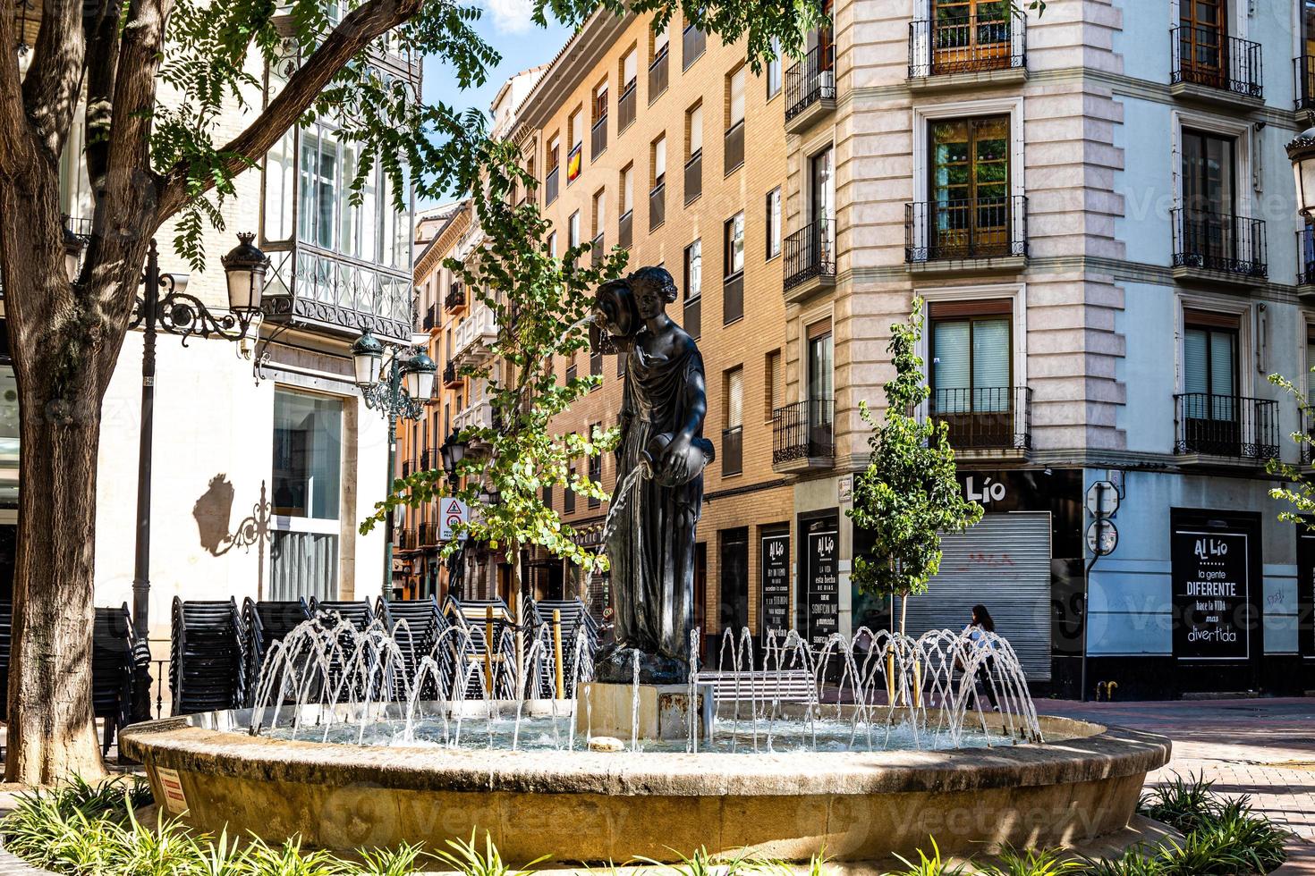 Brunnen im das Spanisch Stadt von Saragossa auf ein warm Sommer- Tag umgeben durch Reihenhäuser foto