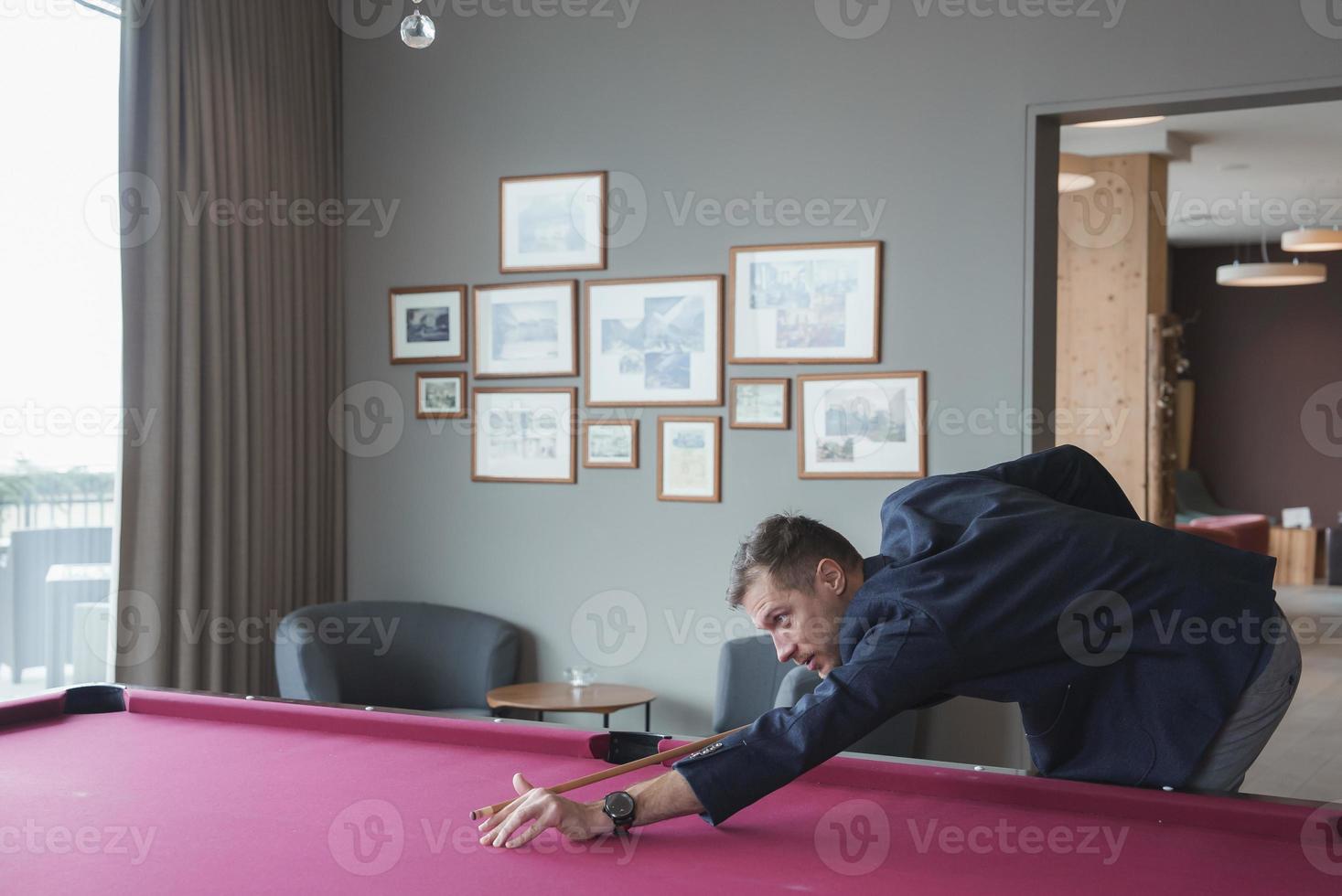 männlich Tourist nehmen Schuss während spielen Snooker im Luxus Hotel foto