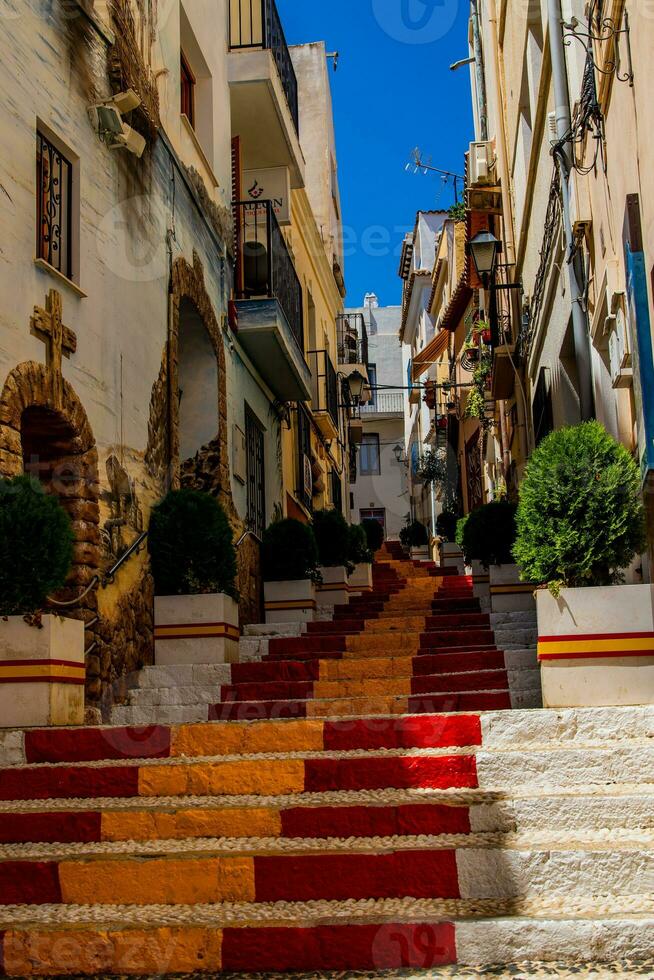 Antiquität Treppe im Calp, Spanien im das alt Stadt, Dorf gemalt rot und Gelb im das Farbe von das Landes Flagge foto