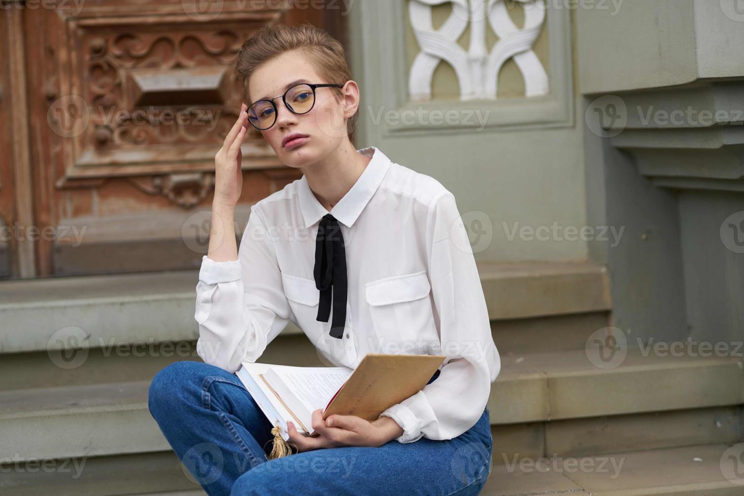 Schüler mit Brille Gehen um das Stadt mit ein Buch Bildung foto
