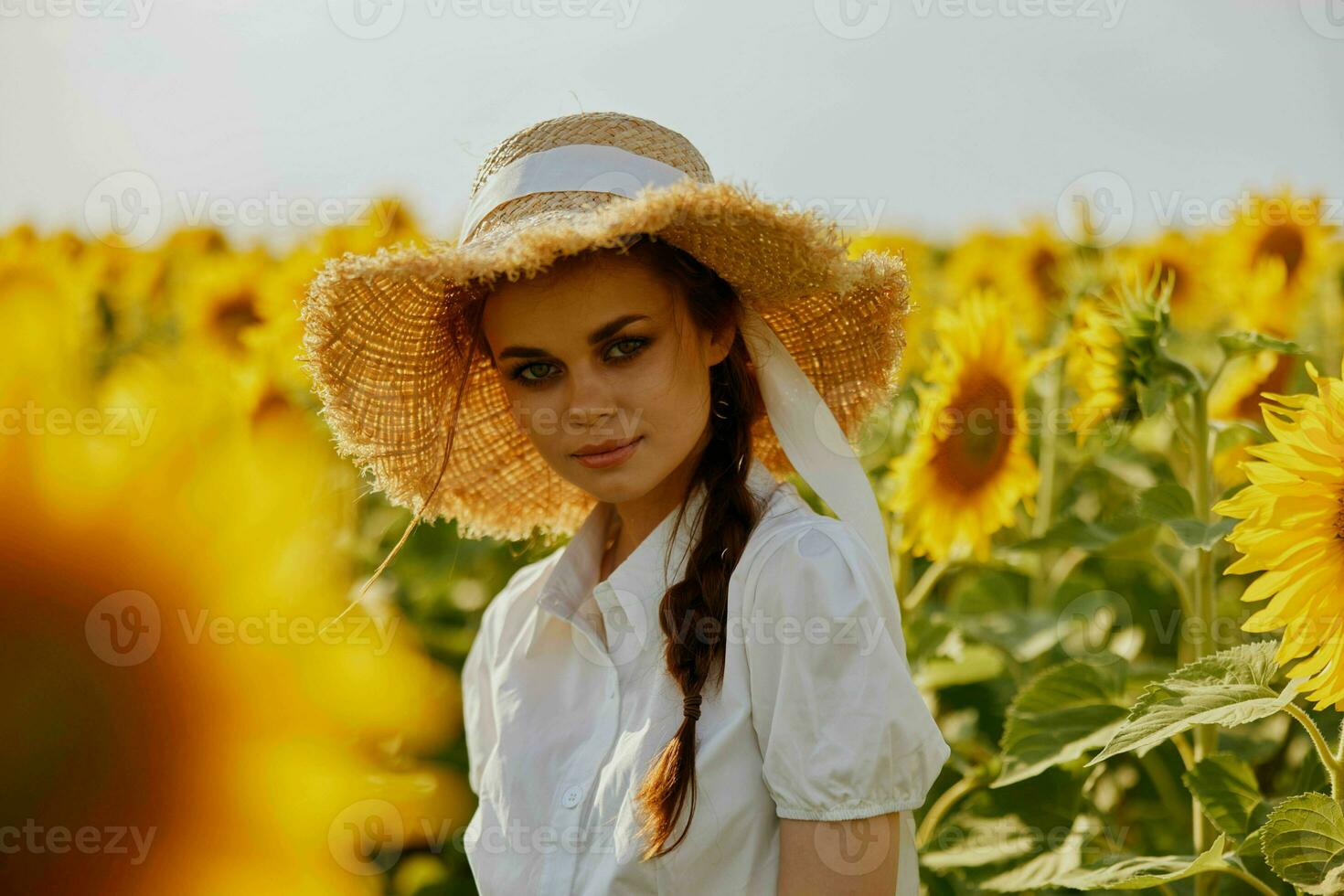 Frau mit zwei Zöpfe im ein Weiß Kleid Gehen auf ein Feld von Sonnenblumen unverändert foto
